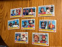 Front view of eight 1983 Topps Baseball Leaders cards spread on a wooden surface