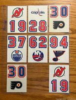Front view of nine sticker sheets showing logos and number decals