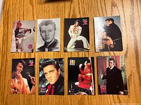 Fronts of eight Elvis Presley trading cards laid out on wooden surface