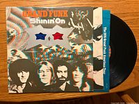 Front cover of Grand Funk Railroad "Shinin' On" LP with record partially removed and tour insert visible