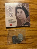 Front of booklet featuring Queen Elizabeth II and plastic sleeve with coins