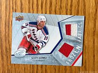 Front of trading card showing photo, branding, and two red jersey swatches