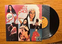 Front of album showing title, artist images and attached vinyl in inner sleeve