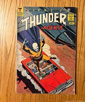 Front cover showing title, issue number, price, artwork of agents in red car