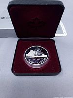 Coin in capsule inside open presentation case