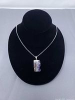 Full necklace on display bust showing chain and pendant