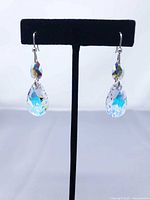 Front view of both earrings hanging on stand