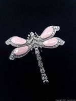 Front view showing pink enamel wings and rhinestone details