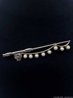 front view of fishing rod brooch with pearlized beads