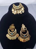 Brooch and both earrings on display stand, front view