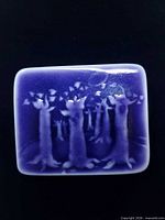 Front view of rectangular purple glazed porcelain brooch with forest scene