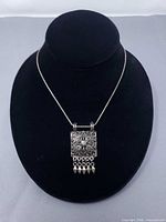 Full view of pendant necklace on display showing overall design and chain