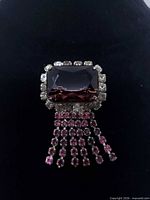 Front view showing purple crystal, clear rhinestone frame and tassel