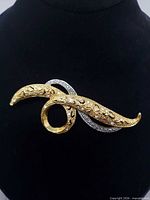 Front view of brooch showing gold and silver tones