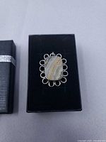 Pendant in box next to lid