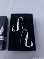 Pair of silver-tone J-shaped drop earrings in black box