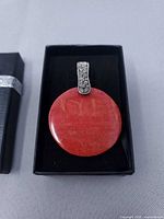 Front view of coral disc pendant in box