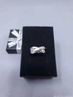 Ring displayed on black gift box, full view