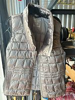 Front view of Calvin Klein quilted puffer vest hanging on hanger showing full zipper, collar and pocket placement