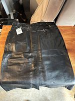 Full view of black leather skirt laid flat