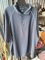 Front view of blue FootJoy polo on hanger showing overall design and condition