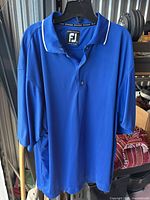 Front view of FootJoy blue XXL golf polo hanging