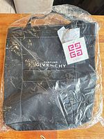 Front view of sealed black Givenchy Parfums tote bag