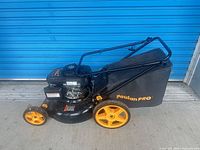 Full left side view of Poulan Pro mower with bag and orange wheels