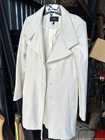 Full view of cream Le Château coat on hanger