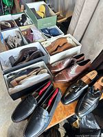 Overall view of multiple shoe boxes and loose pairs on table