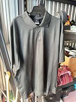 Front view of black Nike Dri-Fit golf polo on hanger