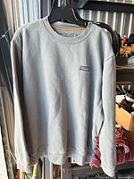 Front view of grey Patagonia crewneck sweater on hanger