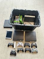 Overall lot showing consoles, controllers, iPad, games and tote