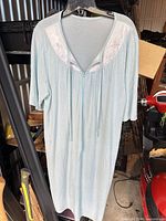 Full view of light blue nightgown on hanger showing lace yoke, ties, sleeves and length