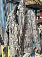 Front view of dark brown quilted puffer jacket hanging
