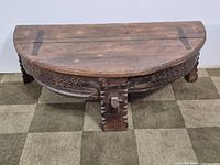 Front view of half-moon Chakki table showing carved base and overall form