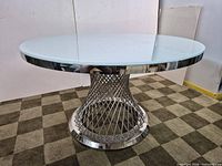 Full view of round glass dining table with stainless steel wire pedestal base