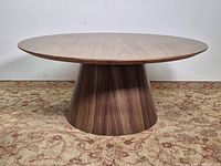 Side view showing walnut pedestal base and round top