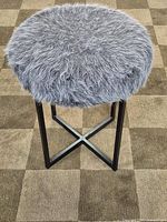 full view of gray faux fur round seat stool with black metal X base