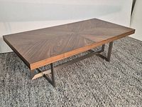 Full view of coffee table showing walnut chevron top and metal base