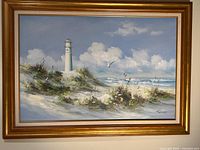 Full view of framed oil painting showing lighthouse scene