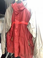 Front view of burgundy and taupe Bonfire snowboard jacket hanging