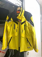 Front view of Descente yellow and black ski jacket on hanger