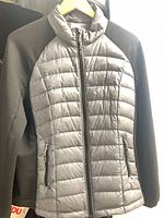 Front view of black and grey down jacket showing quilted panels, zipper and pockets