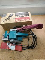 Makita 9924DB belt sander, sanding belt and box overall