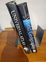 Spine view of both hardcover books on metal bookend