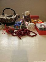 Lot overview showing basket, doll, boxes, ornaments