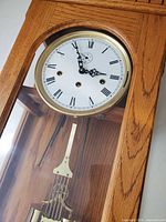 Close-up of dial showing Roman numerals, brass bezel and pendulum section
