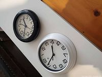 Front view of both clocks showing faces, black and white cases