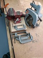 Overall lot showing vise, circular saw and clamps on workbench